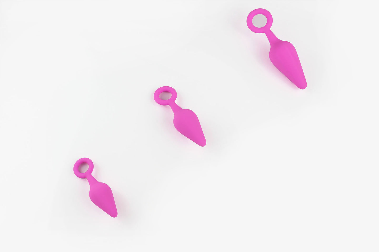 3 pink silicone anal trainers on a white background