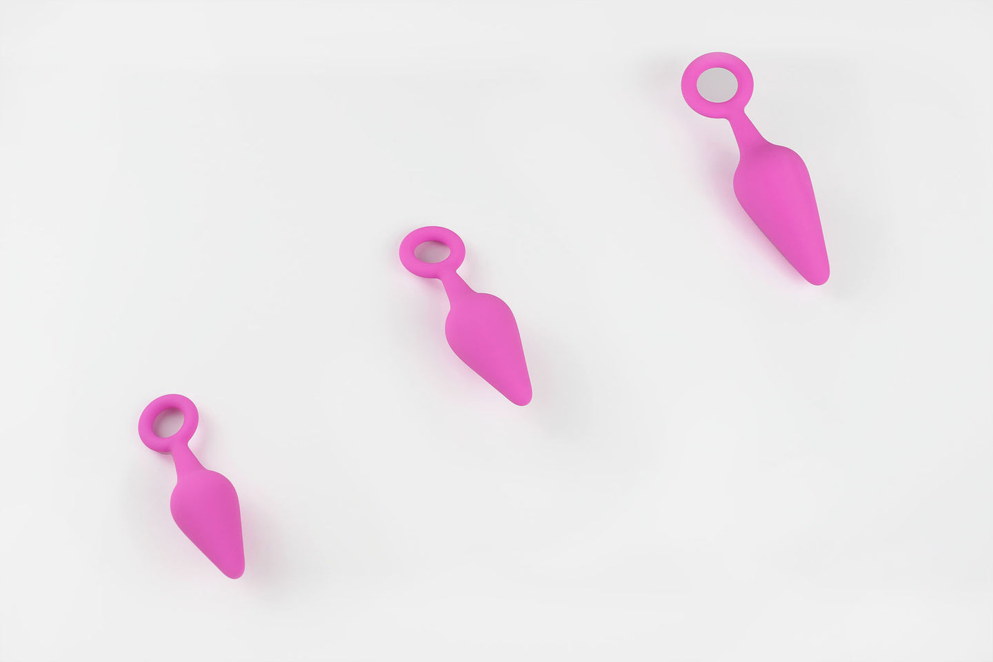 3 pink silicone anal trainers on a white background