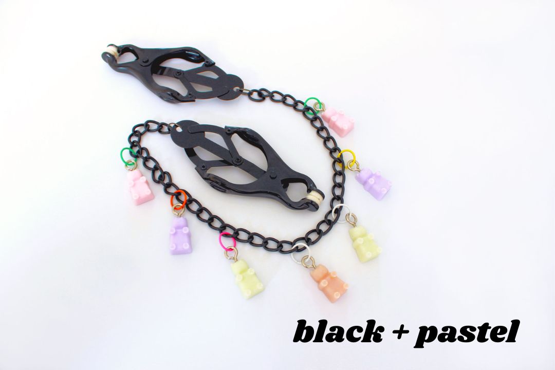 Black clover clamps with chain and multicolored pastel gummy bear charms above text reading black + pastel