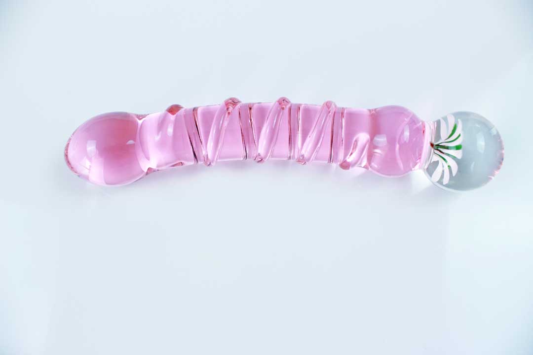 Pink glass ridged dildo with a flower base on a white background.