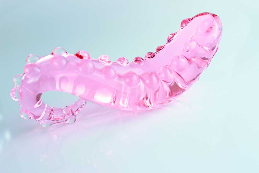 Pink, bumpy Girthy Glass Tentacle Dildo in front of white background