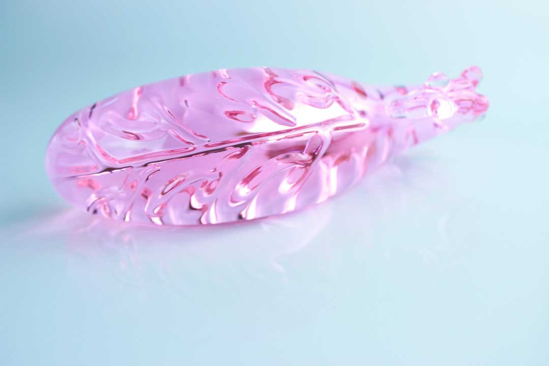 Ridged underside of pink Girthy Glass Tentacle Dildo in front of white background