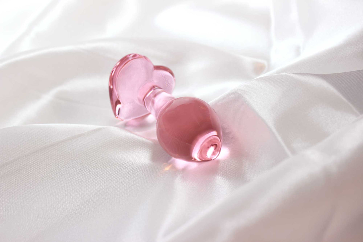 Back view showing teardrop shape of pink glass butt plug with heart base