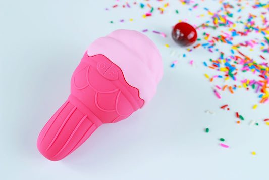 Pink silicone ice cream shaped vibrator on a white background with a cherry and rainbow sprinkles