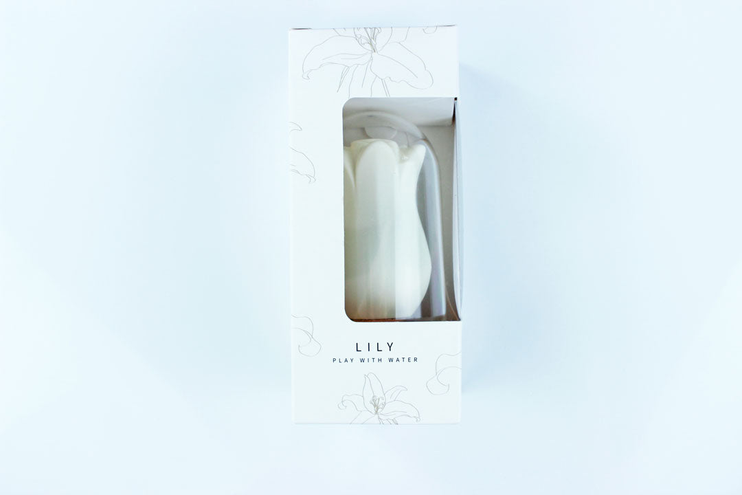 White lily suction vibrator in a white, floral print box with text reading "Lily - Play with Water"