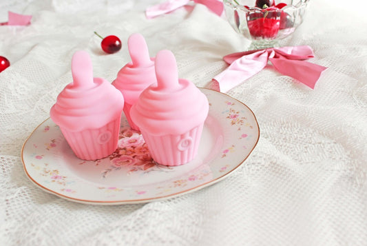 3 pink cupcake shaped licking vibrators on a floral plate with cherries and bows in background