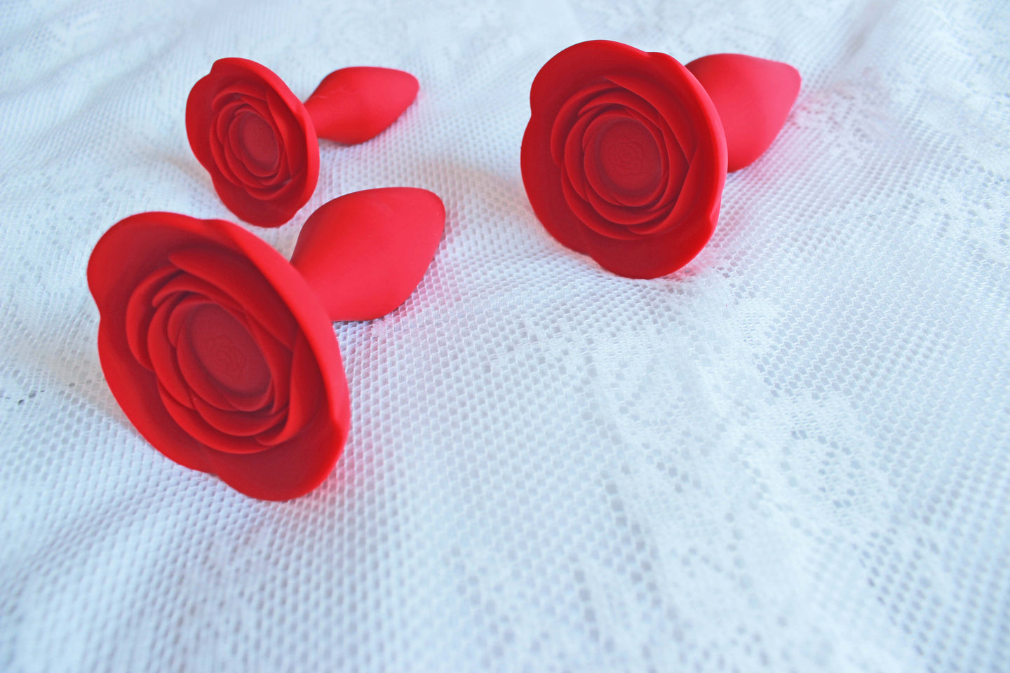 3  red rose anal training butt plugs on a white lace background