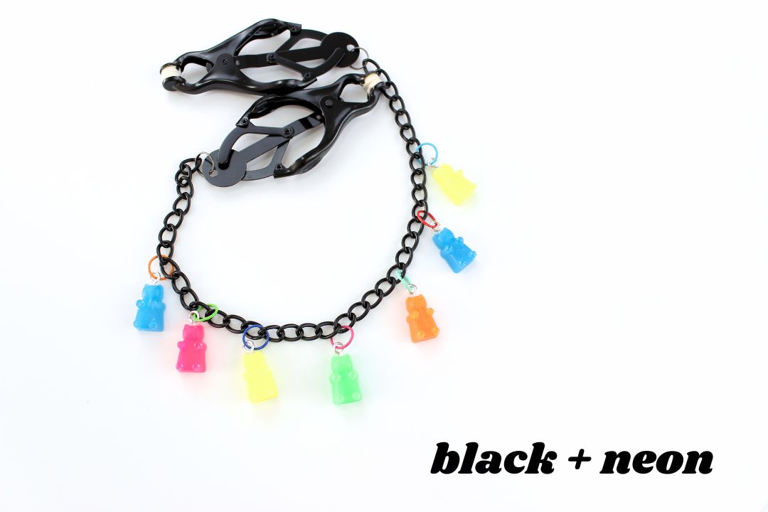 Black clover clamps with chain and multicolored neon gummy bear charms above text reading black + neon