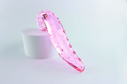 Pink, bumpy Girthy Glass Tentacle Dildo propped on white circle in front of white background