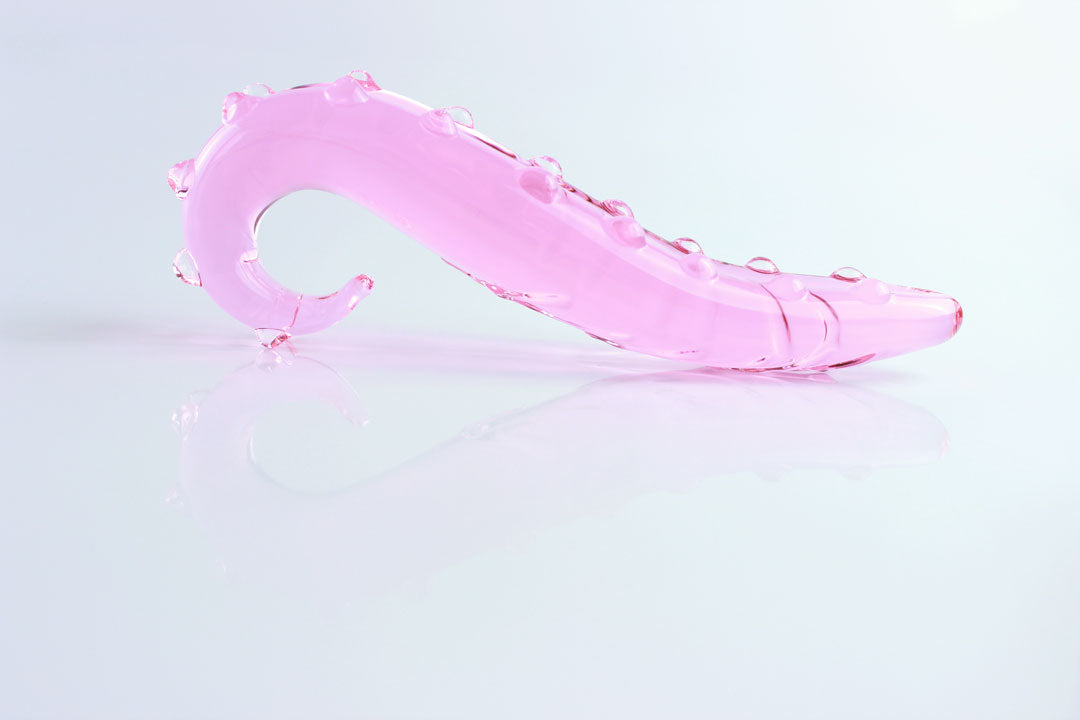 side view of pink, bumpy Girthy Glass Tentacle Dildo in front of white background