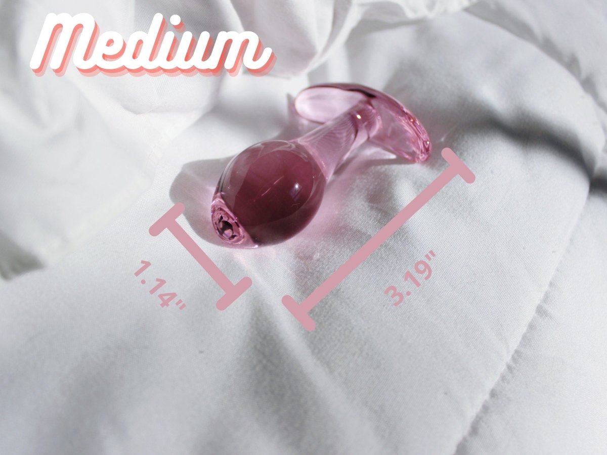 Medium pink glass t bar butt plug laid out on a blanket with measurements reading 3.19 inches tall by 1.14 inches wide.