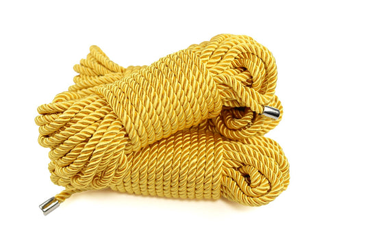 3 bundles of gold satin shibari rope on a white background