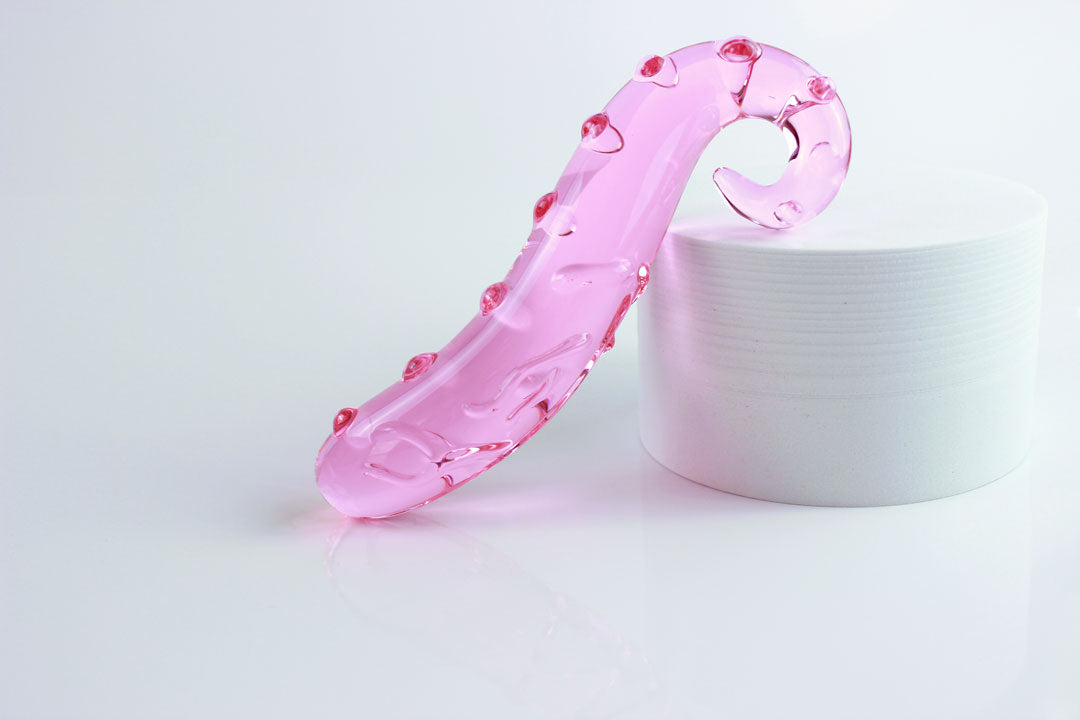 Side shot of 6.125 inch long pink tentacle dildo propped on white circle