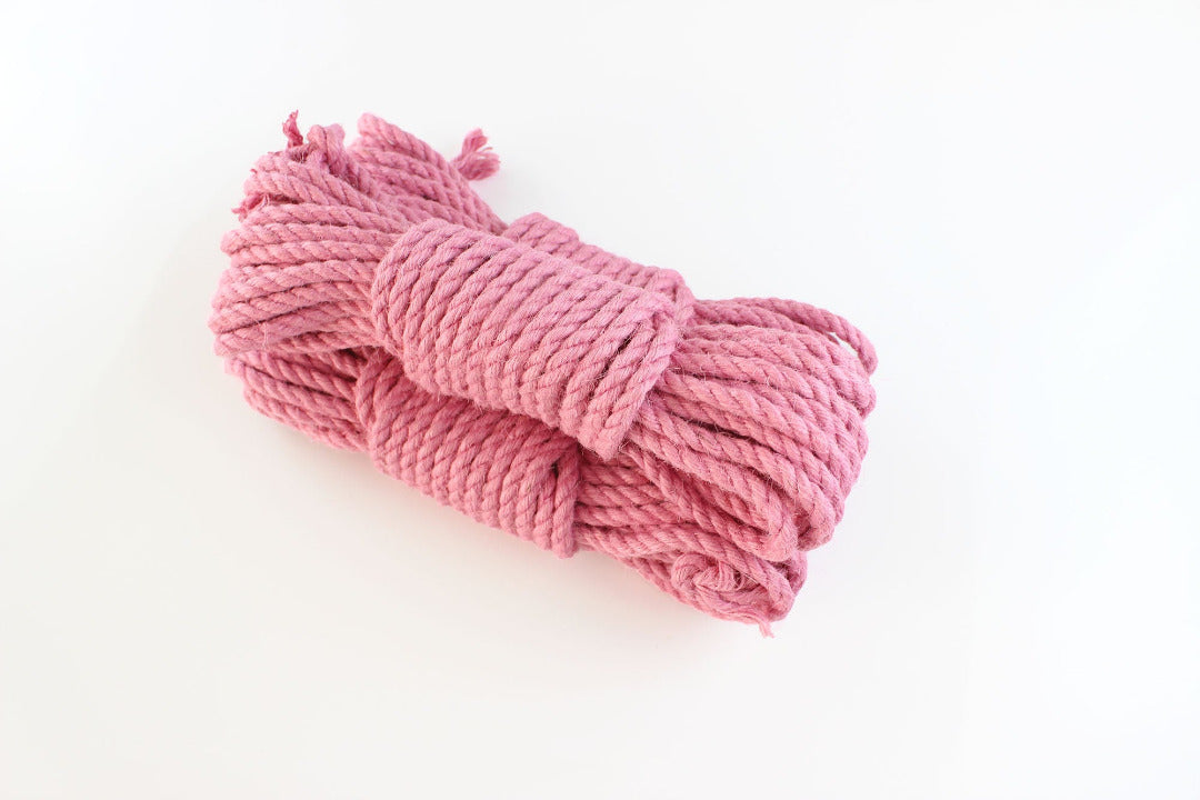 Three bundles of pink jute rope stacked on top of each other on a white background.