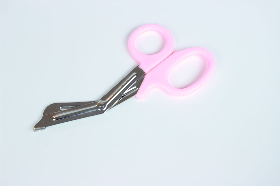 Bondage shears with light pink handles on white background