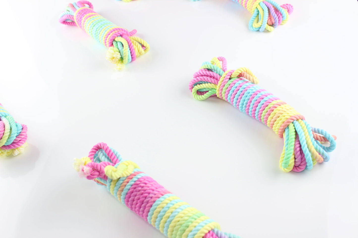 Bundles of multicolor pastel bamboo silk shibari rope on a white background