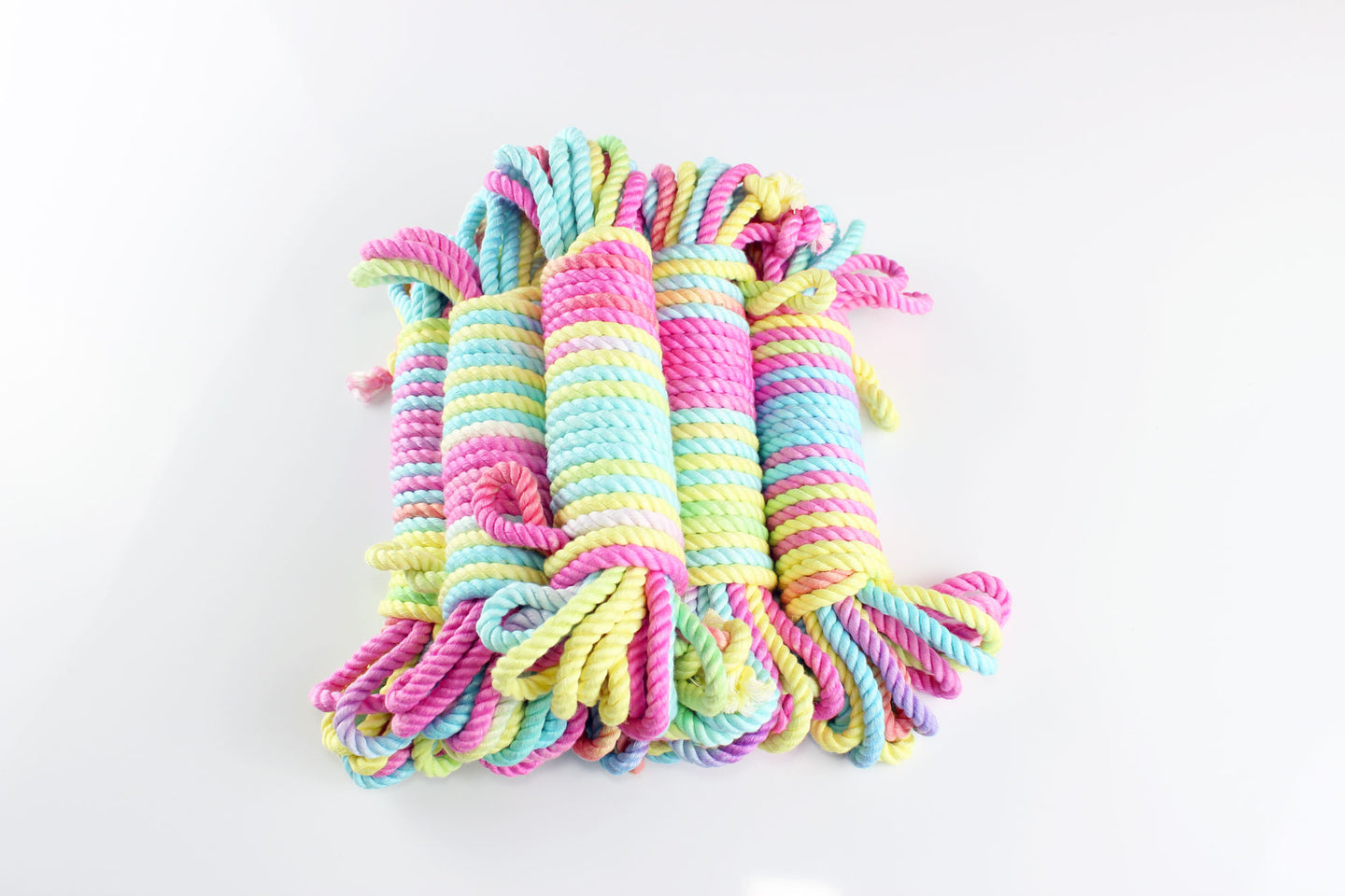 Bundles of multicolor pastel bamboo silk shibari rope on a white background