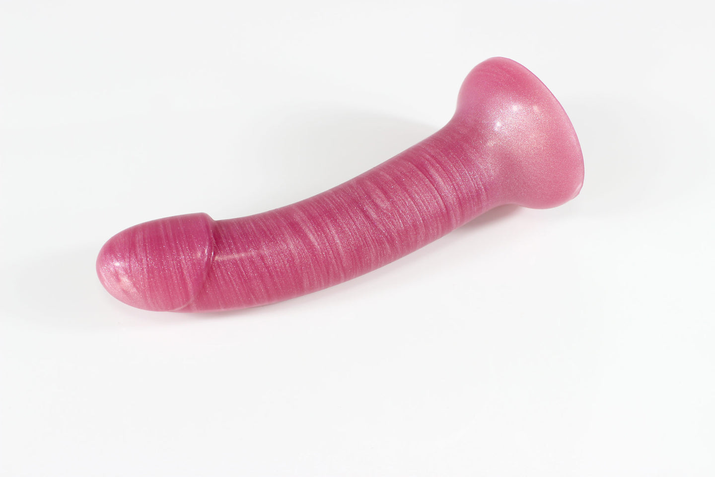 Side view of dark pink, pearlescent silicone dildo on a white background