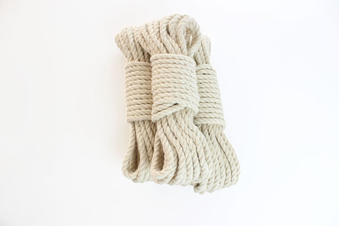 Multiple bundles of white jute rope stacked on top of each other against a white background.