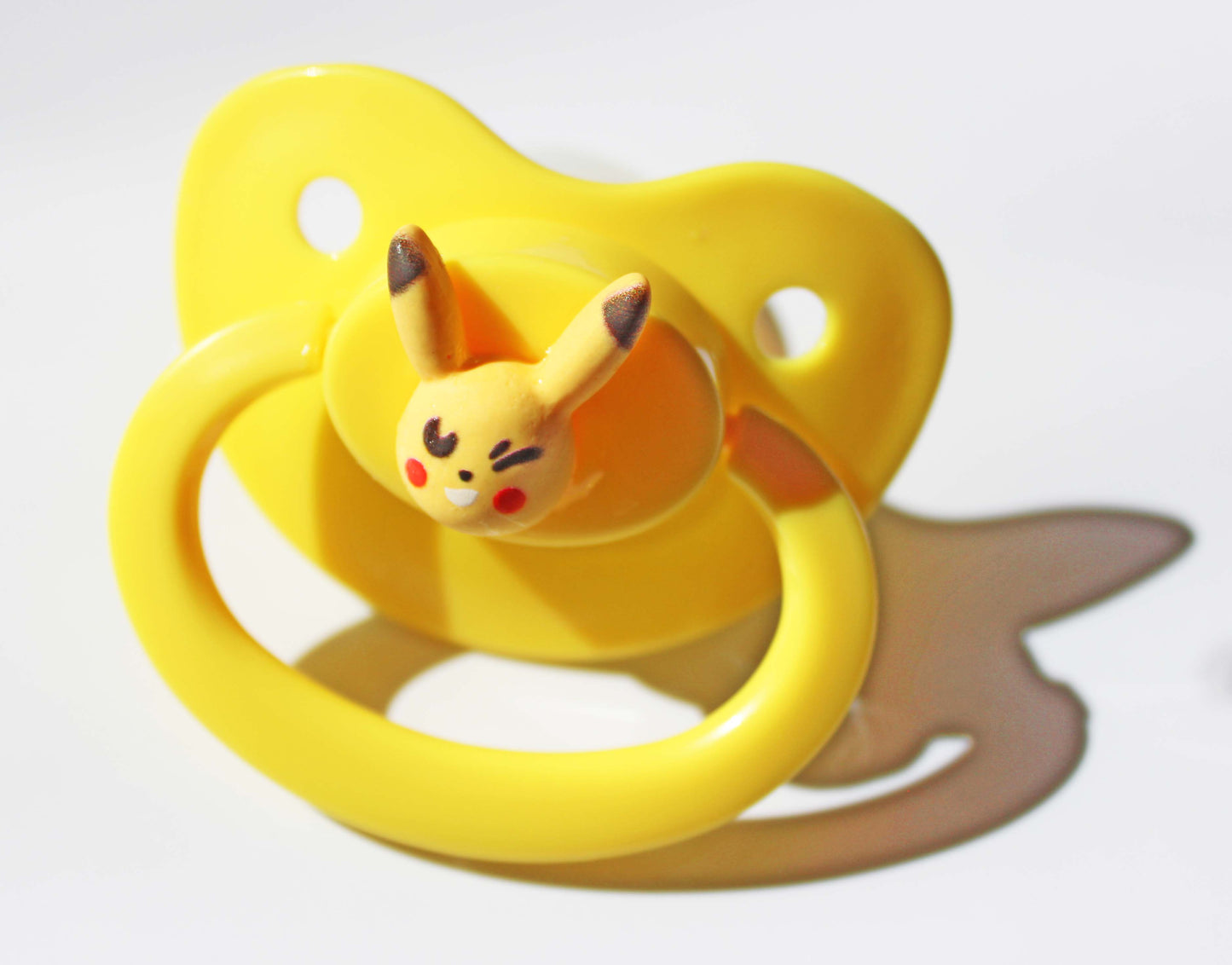 electric mouse pokemon on a yellow pacifier on a white background.