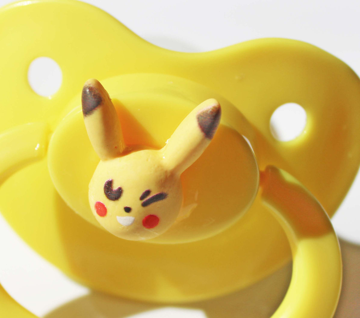 electric mouse pokemon on a yellow pacifier on a white background.