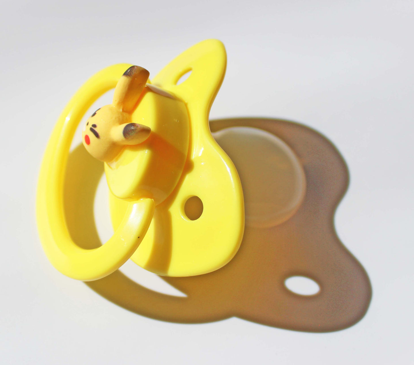 electric mouse pokemon on a yellow pacifier on a white background.