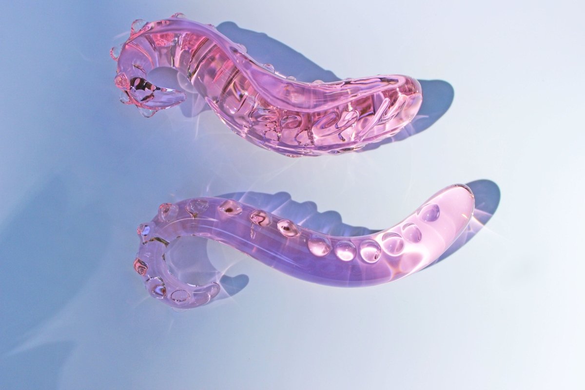 Girth and long pink glass tentacle dildos on white background