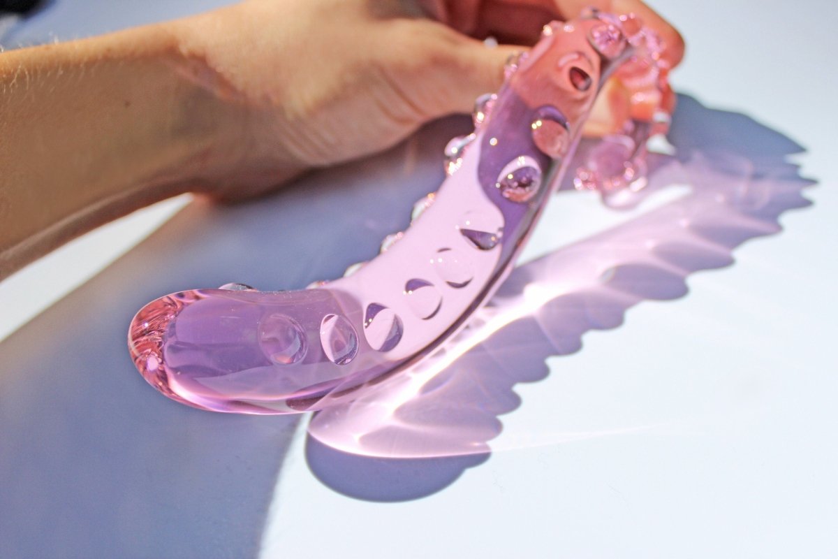 Long 6.25 inch pink glass tentacle dildo being held on white background