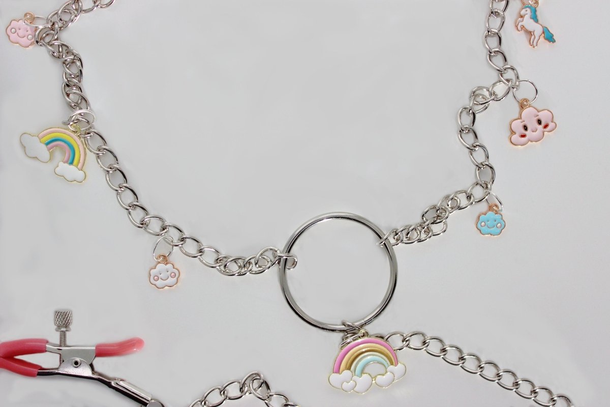 Close up of 3 chain nipple and clit adjustable screw clamps with rainbow, cloud, and unicorn charms